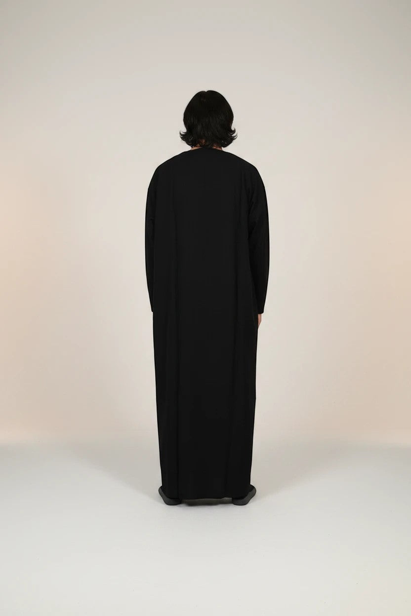 Khayr Thobes black traditional Islamic thobe robe for men, long sleeves, flowing silhouette, embroidered neckline detail.