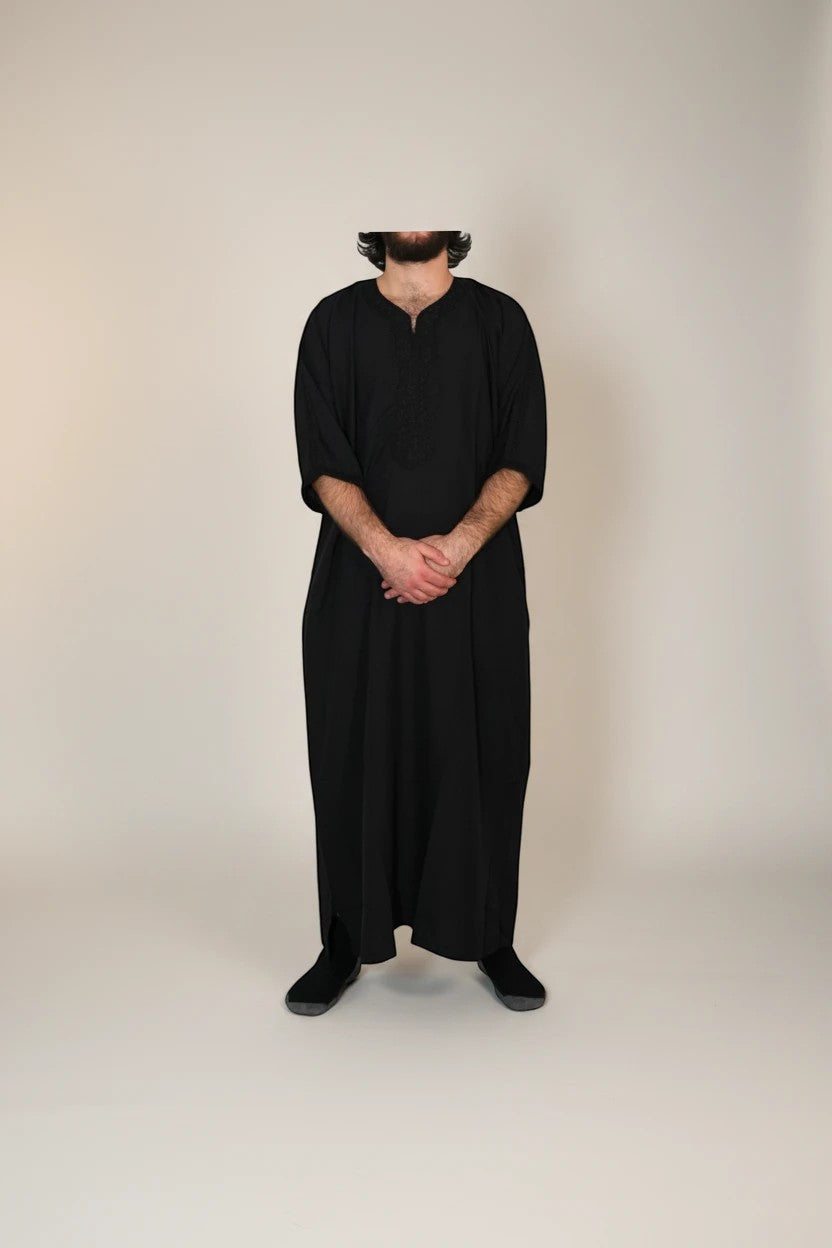 Khayr Thobes black traditional Islamic thobe robe with embroidered neckline and side slits. Relaxed fit, modest attire.