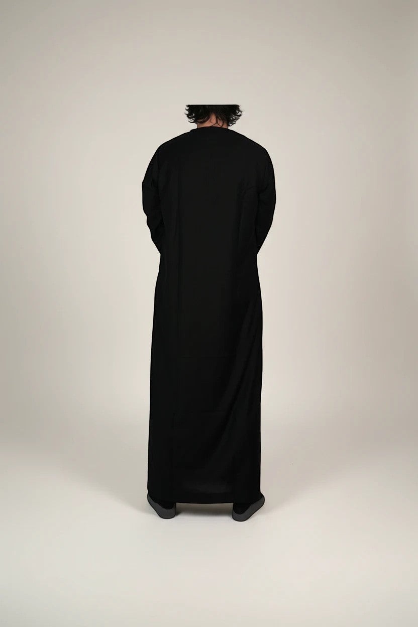Khayr Thobes black Omani thobe with embroidered neckline and cuffs, made from breathable fabric.
