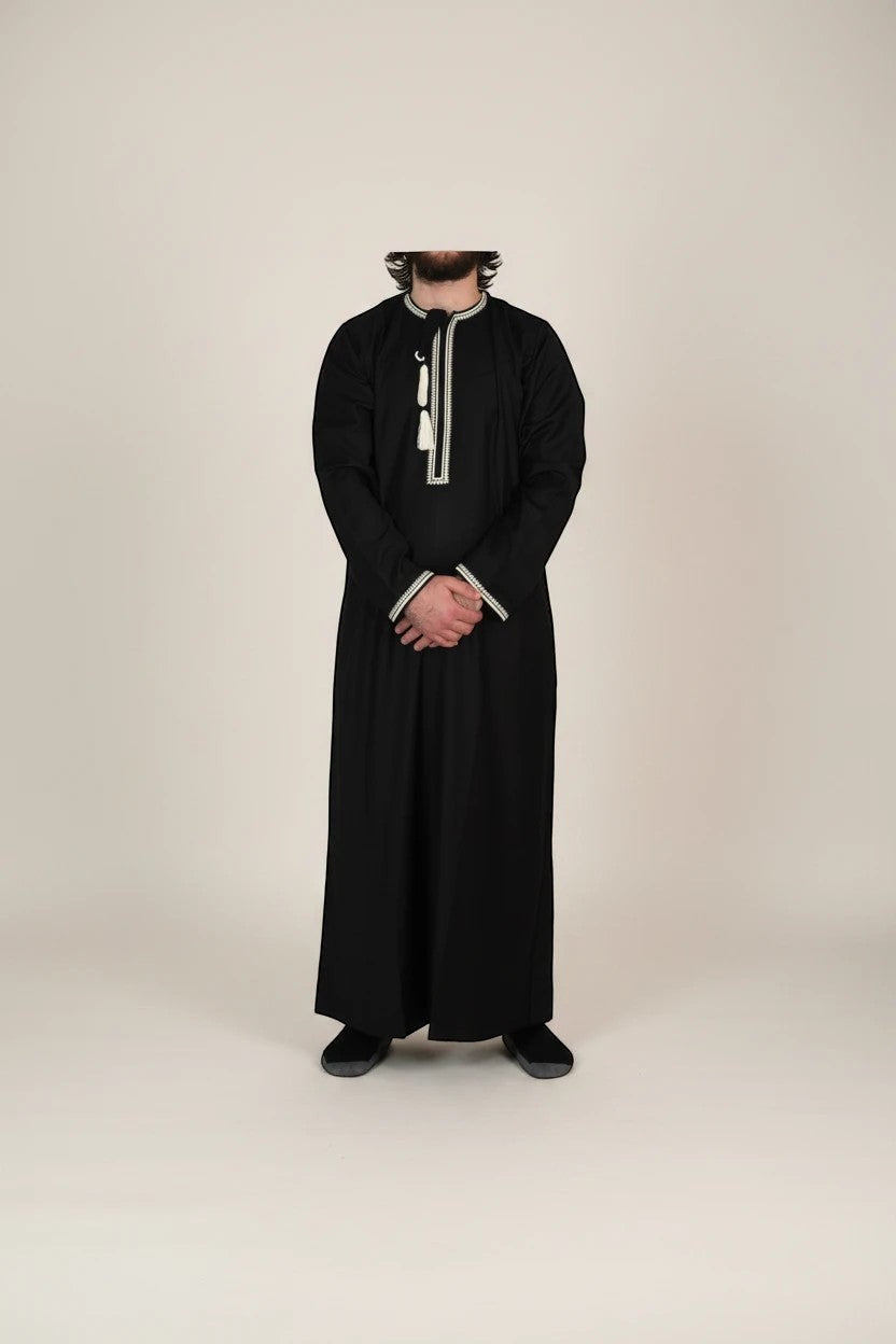 Khayr Thobes black Omani thobe with embroidered neckline, cuffs, and tassels. Long sleeves, relaxed fit.