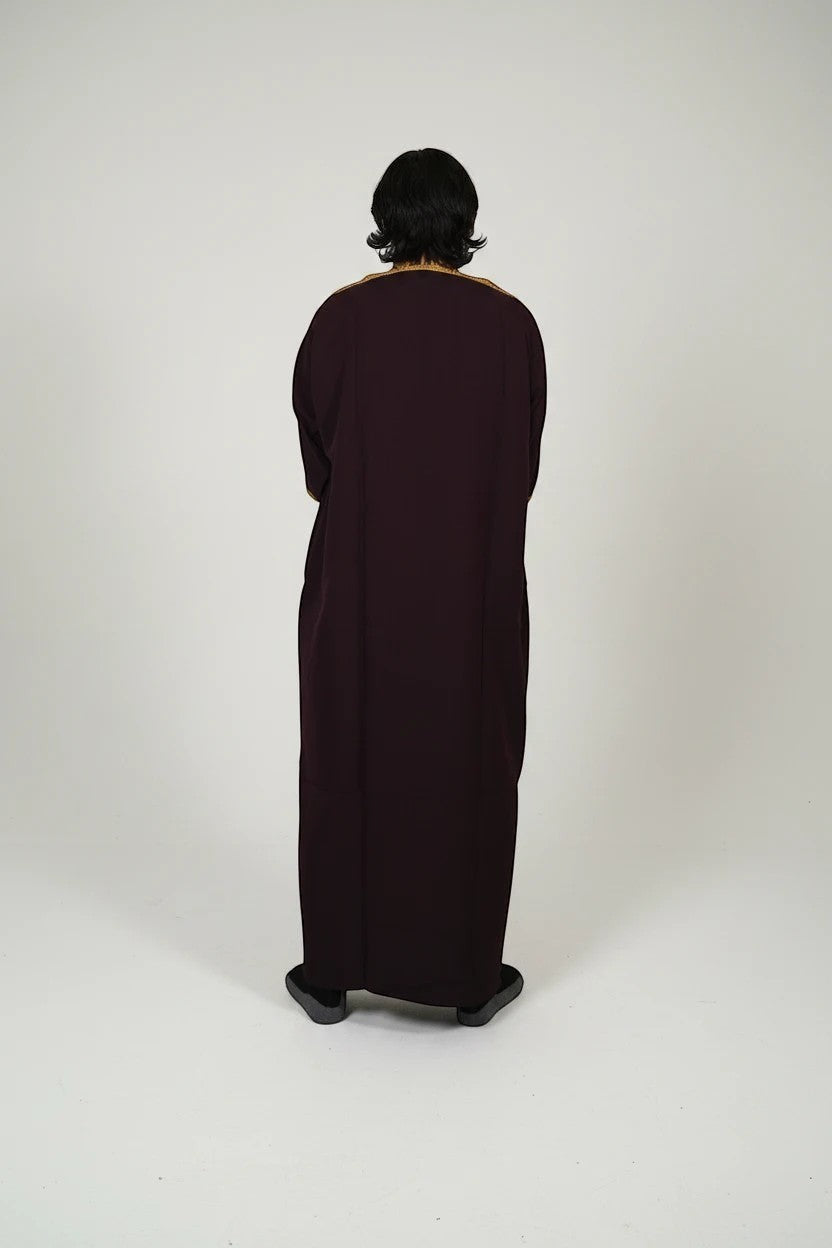 Khayr Thobes deep plum embroidered kaftan thobe with gold trim on neckline and cuffs. Relaxed fit with side slits.