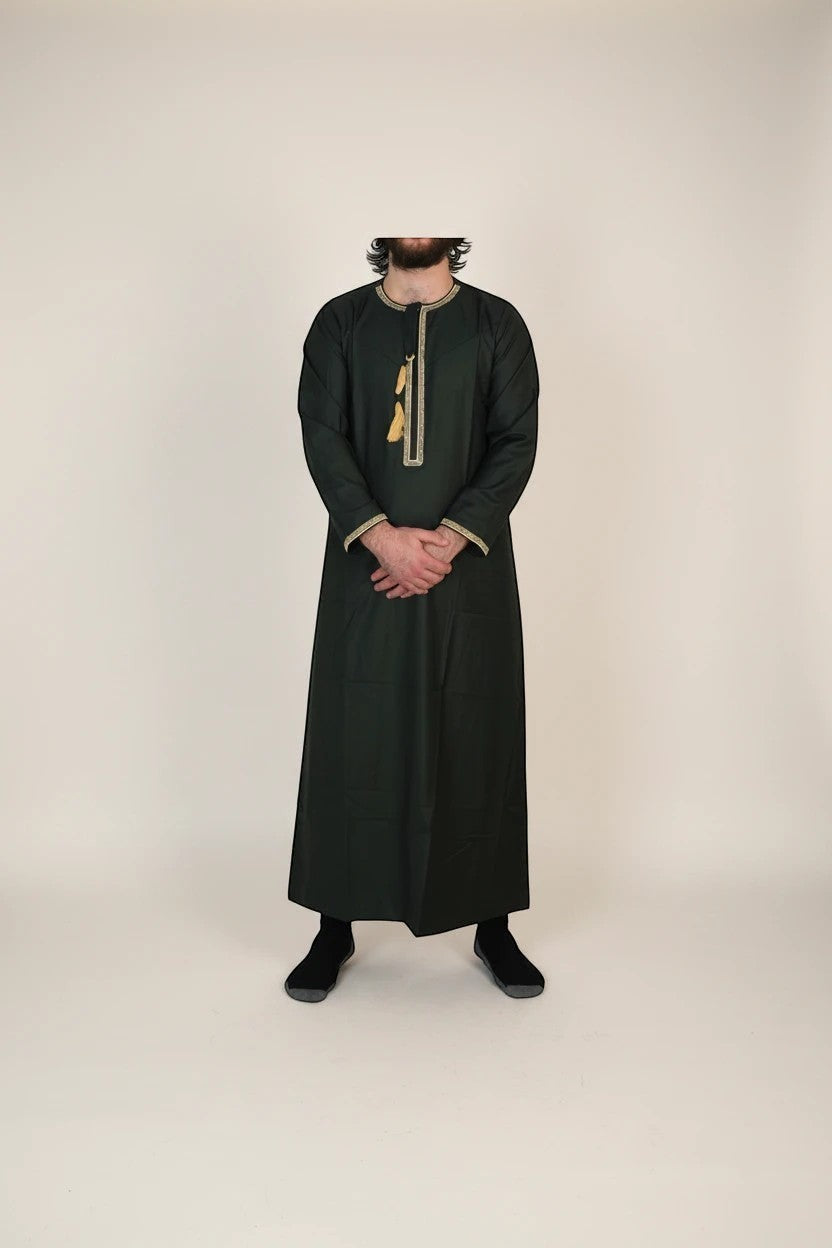 Khayr Thobes forest green men's long sleeve thobe with gold trim and tassel accent.