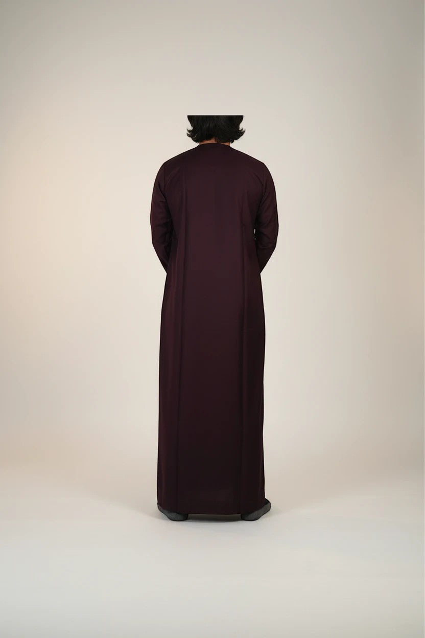 Khayr Thobes deep plum traditional thobe with tassel detail and white embroidery on neckline and cuffs.