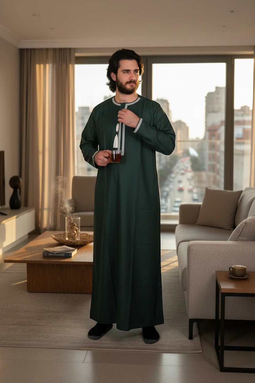 Khayr Thobes traditional Islamic thobe in deep forest green with white embroidery and tassel detail. Long sleeves, round neckline.