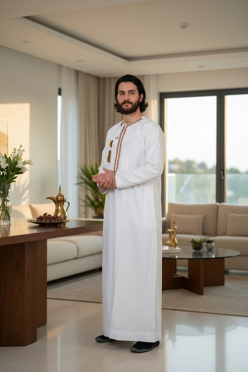 Khayr Thobes traditional white men's thobe with gold embroidered neckline and tassels.